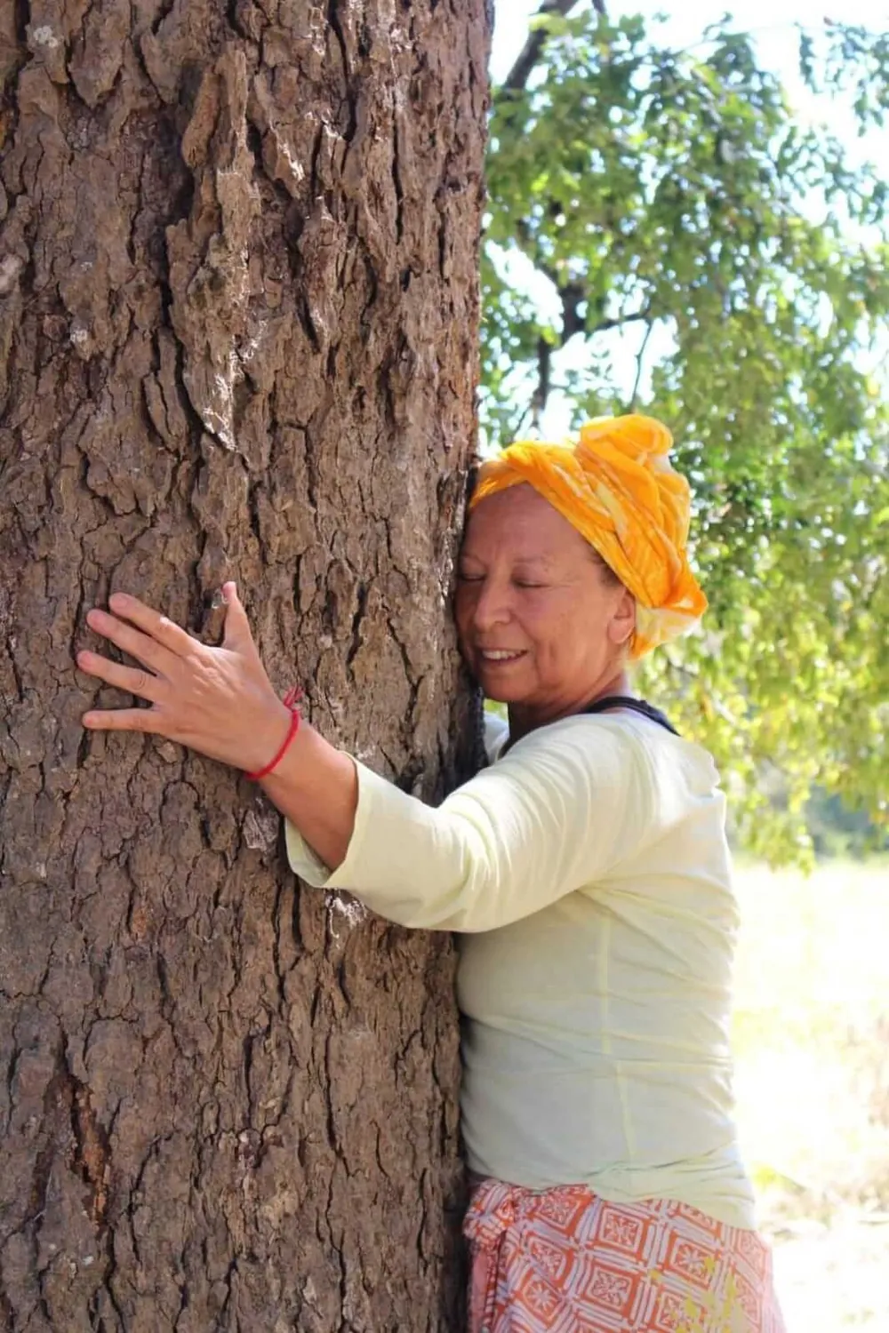 Una mujer abrazando un árbol