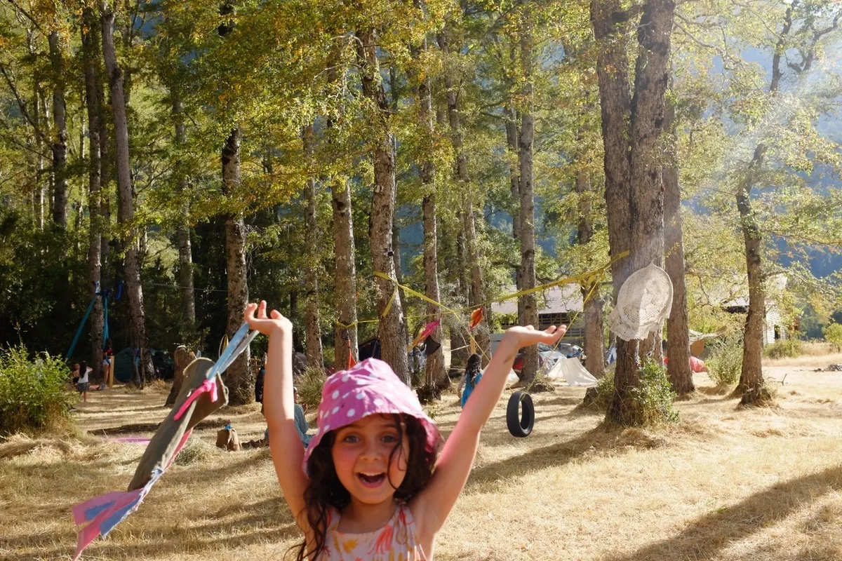 Una niña jugando con cintas entre los árboles